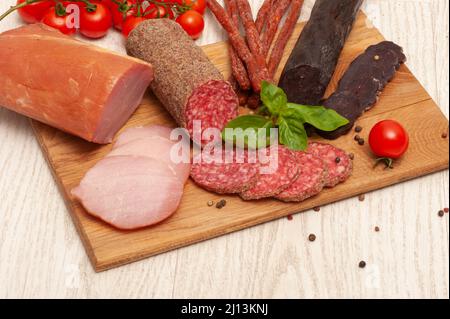 Geräuchertes Fleisch auf einem Holzbrett Stockfoto