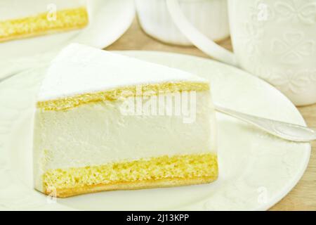 Tischeinstellung mit Frischkäse-Kuchen und Kaffeetassen Stockfoto