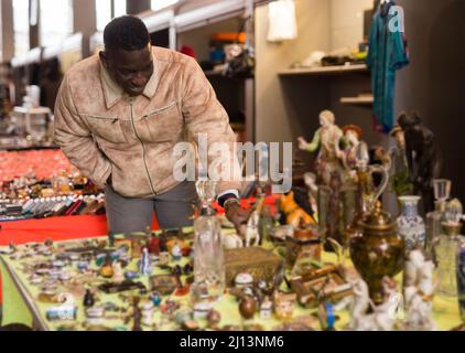 Afroamerikanischer Mann wählt Antiquitäten auf dem Flohmarkt Stockfoto