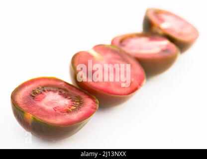 Schwarze Hälften von Tomaten auf weißem Hintergrund Stockfoto