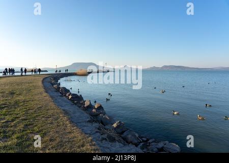 Touristen zu Fuß auf Fonyód Pier am Plattensee Winter Frühling Zeit. Stockfoto