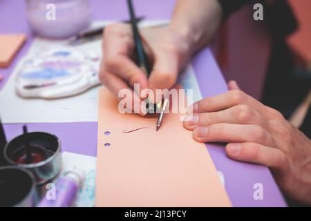 Prozess der Kalligraphie Handschrift mit einer Tintenfontäne Feder, Kalligraph üben Schreiben auf Postkartenpapier mit Stiftpinsel und Zeichenstift wi Stockfoto