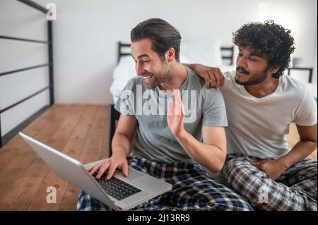 Schwule Männer, die ihren Laptop für Skype-Kommunikation nutzen Stockfoto
