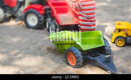 Kinder, die im Sandkasten Sandkasten spielen, Kinder mit Spielzeugauto, Spielplatz in einer Kindertagesstätte Stockfoto