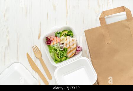 Essen zum Mitnehmen. Gesundes Mittagessen auf weißem Holzhintergrund. Platz kopieren, Draufsicht. Stockfoto