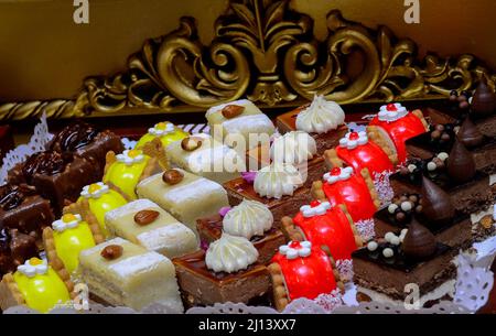 Verschiedene Mini-Kuchen mit Sahne, Schokolade und Beeren-Süßigkeiten auf der marokkanischen Hochzeit angeboten Stockfoto