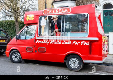 Ein fröhlicher Verkäufer sieht aus einem traditionellen Eiswagen, London, Großbritannien Stockfoto