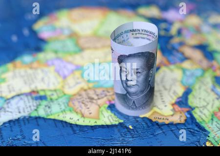 Chinesischer Yuan auf der Karte von Afrika und Saudi-Arabien. Konzept des Ölkaufs, wirtschaftliche Zusammenarbeit zwischen den Ländern Peking und dem Nahen Osten Stockfoto