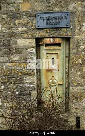 Ein blassgrüner GR- oder George Rex-Briefkasten, der in eine Hauswand im Cotswolds-Dorf Brimpsfield in Gloucestershire eingebettet ist Stockfoto