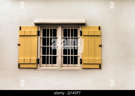 Ein Zimmer mit Aussicht Zugeschnittene Aufnahme eines Fensters mit gelben Fensterläden. Stockfoto