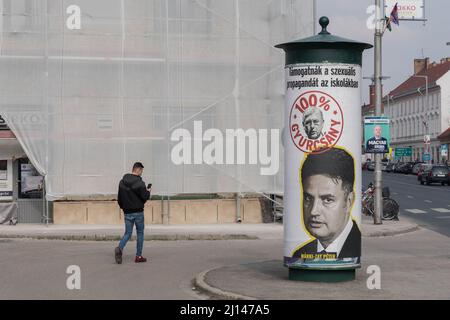 Mosonmagyarovar, Ungarn. 18. März 2022. Ein Mann kommt auf der Straße an einem Wahlplakat von Peter Marki-Zay, dem Führer der ungarischen Oppositionskoalition, die für Ungarn vereint ist, vorbei. Mosonmagyarovar ist die Stadt im Nordwesten Ungarns, etwa 160 Kilometer von der ungarischen Hauptstadt Budapest entfernt. Peter Marki-Zay wird Premierminister Viktor Orban bei den bevorstehenden Parlamentswahlen, die am 3.. April 2022 stattfinden werden, herausfordern. (Foto von Tomas Tkacik/SOPA Images/Sipa USA) Quelle: SIPA USA/Alamy Live News Stockfoto