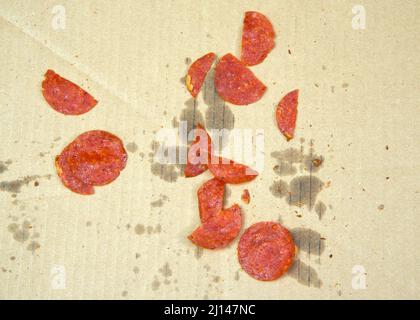 Draufsicht auf Reste von Pepperoni in einer Lieferkiste, nachdem die Pizza vollständig verzehrt wurde. Stockfoto