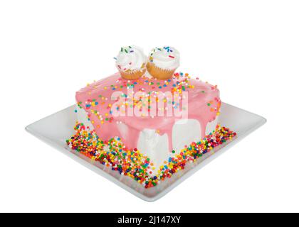 Weiße Vanille hat quadratischen Kuchen auf einem quadratischen Porzellanteller mit Erdbeer-Ganache und Regenbogenstreuseln angegossen. Zwei Cupcakes nebeneinander Stockfoto