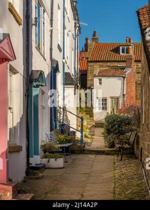 Traditionelle, weiß gerenderte Küstenhütten an einer schmalen Gasse in Robin Hood's Bay, North Yorkshire. VEREINIGTES KÖNIGREICH Stockfoto