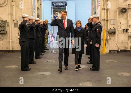 Norfork, Usa. 20. März 2022. Der Gouverneur von Virginia, Glenn Youngkin, links, und seine Frau, Suzanne Youngkin, grüßen ihn, als er an den Sideboys vorbeikommt, nachdem er an Bord des Amphibientransportschiffes USS Arlington der San Antonio-Klasse angekommen war, 20. März 2022 Norfork, Virginia. Youngkin kam, um mit den Matrosen und Marineinfanteristen vor ihrem Einsatz bei der Kearsarge Amphibious Ready Group zu sprechen. Quelle: MCS Keith Nowak/US Navy/Alamy Live News Stockfoto