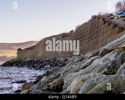 Seeverteidigung in Robin Hood's Bay, mit den Klippen von Ravenscar in der Ferne. North Yorkshire. Stockfoto