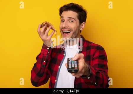 Funny Guy Essen Pizza Halten Fernbedienung Fernsehen Stockfoto