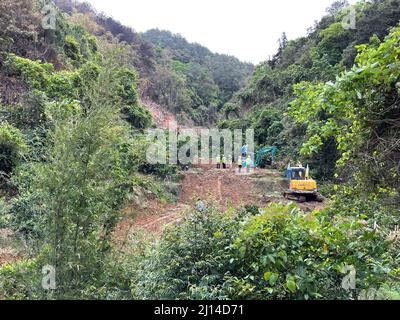 (220322) -- NANNING, 22. März 2022 (Xinhua) -- Foto mit einem Mobiltelefon zeigt einen Bagger, der einen Weg zu einem Flugzeugabsturz im Landkreis Tengxian, südchinesische Autonome Region Guangxi Zhuang, öffnet, 22. März 2022. Die Boeing 737 von China Eastern Airlines mit 132 Personen an Bord, Die von Kunming nach Guangzhou abreiste, stürzte um 2:38 Uhr in eine bergige Gegend in der Nähe des Dorfes Molang im Landkreis Tengxian in der Stadt Wuzhou ein und verursachte einen Bergbrand, wie die regionale Notfallverwaltungsabteilung mitteilte. Die Rettung ist im Gange. (Xinhua/Zhou Hua) Stockfoto