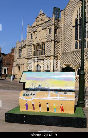 Eine von sieben Explore-a-Book Bänken in West Norfolk. Das Hotel liegt vor den Gilden- und Stadthallen von King's Lynn aus dem 15.. Jahrhundert Stockfoto