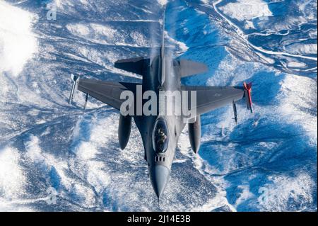 Central Alaska, Usa. 16. März 2022. Ein Kampfjet der US-Luftwaffe F-16 Fighting Falcon, der dem 180. Fighter Wing zugewiesen wurde, nähert sich während der Operation Arctic Edge, 16. März 2022, über Alaska einem Stratotanker der KC-135R an. Die Übung des Nordkommandos ist Teil der jüngsten militärischen Schritte, um das russische Engagement in der Ukraine zu verhindern. Kredit: SSGT. Taylor Crol/USA Air Force/Alamy Live News Stockfoto