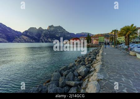 Nago–Torbole, Italien - 26. Februar 2022: Blick auf das Nordufer des Gardasees, mit Einheimischen und Besuchern, an einem klaren Wintertag, in Nago–Torbole, Tren Stockfoto