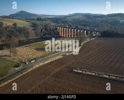 Luftaufnahme zum Gelände des römischen Fort-Komplexes Trimontium von Newstead in den schottischen Grenzen. Amphitheater im Bad mit Schatten von Bäumen. Stockfoto