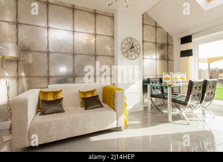 Wohn-Essbereich im modernen Haus, Sofa-Couch, Esstisch und Stühle, Fliesenboden. Stockfoto