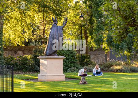 Die Statue von Bischof Henry Wardlaw, der zwei Studentinnen im St Marys College Quadrangle, University of St Andrews, Fife, Schottland, beobachtet Stockfoto