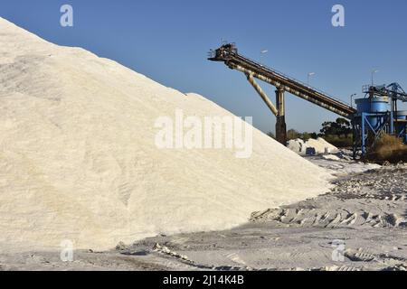 Salzproduktionsstandort - Förderband, Salz wird nach der Ernte aus Salzteichen, Huelva Spanien Europa, angestapelt. Stockfoto