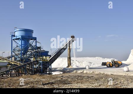 Salzproduktionsstandort - Förderband, Salz wird nach der Ernte aus Salzteichen, Huelva Spanien Europa, angestapelt. Stockfoto