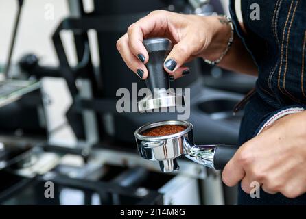 Nahaufnahme der weiblichen Barista-Hände während der Arbeit im Coffee Shop Stockfoto