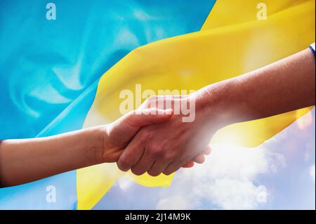 Sonnige ukrainische Landesflagge mit helfenden Händen als Unterstützung Stockfoto