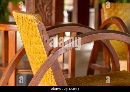 Ein Stuhl aus Holz und Rattan mit klassischem Design, der mit brauner Farbe endet, ein Beispiel für einen Stuhl für den Innenraum Stockfoto
