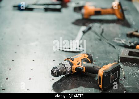 Workshop-Szene. Werkzeuge liegen auf Metalltisch in der Werkstatt, Garagenstil Stockfoto