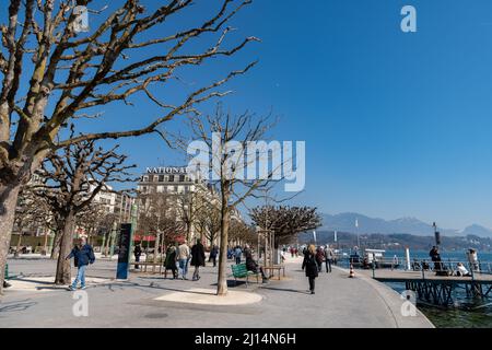 Luzern, Schweiz, 10. März, an einem sonnigen Tag laufen 2022 Menschen am Ufer entlang Stockfoto