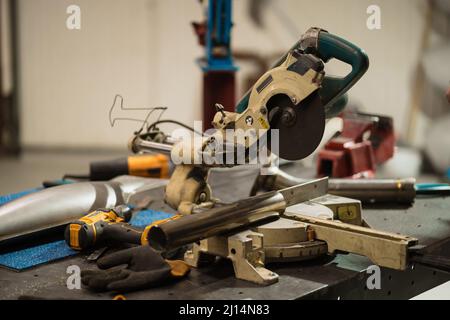 Workshop-Szene. Werkzeuge liegen auf Metalltisch in der Werkstatt, Garagenstil Stockfoto