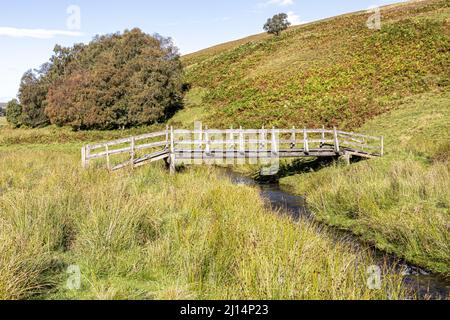 Eine hölzerne Fußgängerbrücke über Conglass Water bei Blairnamarrow in der Nähe von Tomintoul, Moray, Schottland, Großbritannien. Stockfoto