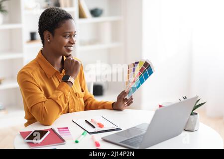 Kreative junge schwarze Designerin, die auf einem Laptop arbeitet Stockfoto