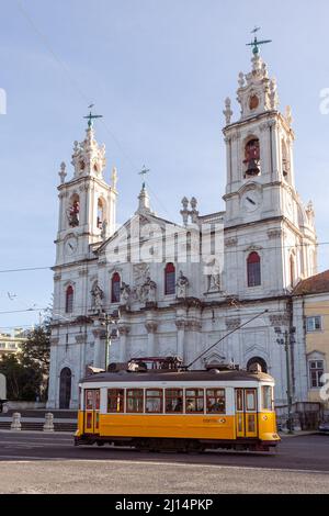 Die ikonische gelbe Tram 28 fährt vor der Basilica da Estrela, der historischen neoklassizistischen Kirche im Zentrum von Lissabon, Portugal. Stockfoto