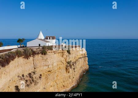 Capela da Nossa Senhora da Rocha, eine kleine Kapelle auf einer atemberaubenden Klippe, in der Küstenstadt Alporchinhos an der Algarve, Portugal Stockfoto