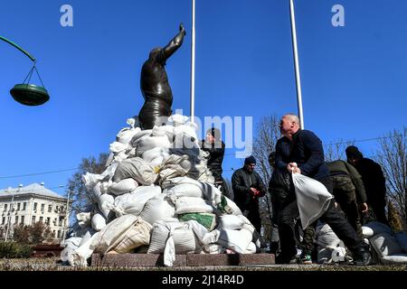 ZAPORIZHZHIA, UKRAINE - 22. MÄRZ 2022 - örtliche Freiwillige, Historiker und Museumsmitarbeiter legen Sandsäcke um das Denkmal des ukrainischen Gewichtheber, Stockfoto