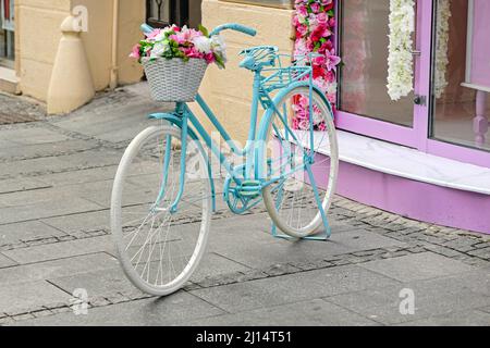 Hellblauer Fahrradparket für Damen auf der Straße mit Blumenkorb Stockfoto