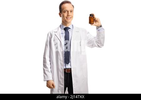 Männlicher Arzt, der eine Flasche Pillen zeigt und isoliert auf weißem Hintergrund auf die Kamera schaut Stockfoto