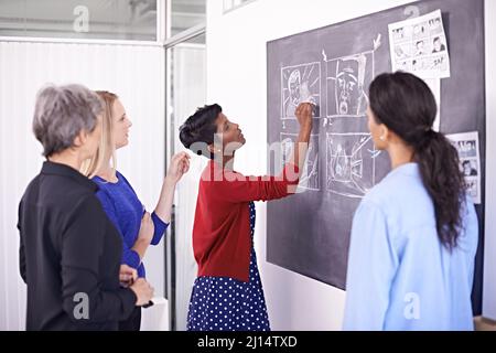 Abschluss der Abbildung. Aufnahme einer Gruppe von Designerinnen, die in ihrem Büro an einer Tafel arbeiten. Stockfoto