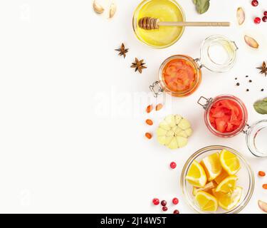 Natürliches Heilmittel für Immunität Gesundheit. Gesunde Lebensmittelzusammensetzung mit wilden Preiselbeeren, Honig, Knoblauch, Sanddorn, Zimtstangen und Gewürzen auf Weiß Stockfoto