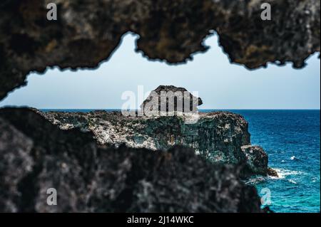 Das Foto zeigt den Atlantik mit einer felsigen Küste. Der Strand der exotischen Insel enthält viele Felsen und Grotten. Die felsige Landschaft und das Meer sind Stockfoto