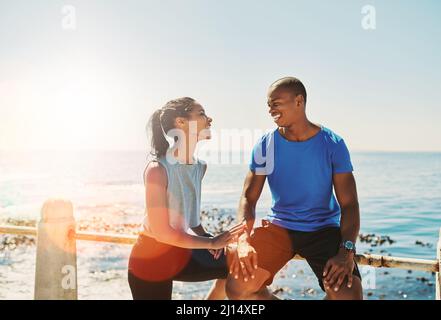 Sie motivieren sich gegenseitig, weiter zu machen. Aufnahme eines jungen, sportlichen Paares, das gemeinsam laufen soll. Stockfoto