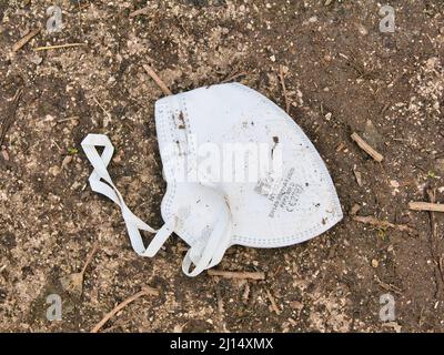 Eine gebrauchte, weggeworfene Handanhy HY8220 FFP2 Gesichtsmaske (Einweg-Atemschutzmaske), die als Abfall auf einem ländlichen Wanderweg in Wirral, England, Großbritannien, weggeworfen wurde Stockfoto