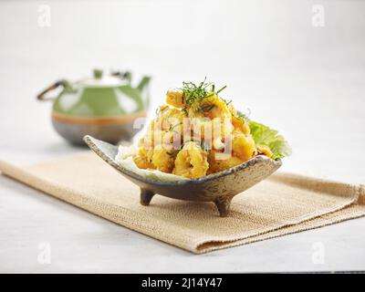 Gesalzenes Ei Calamari mit thailändischen Kräutern in einem Gericht isoliert auf Serviette Seitenansicht auf grauem Hintergrund Stockfoto