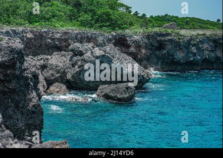 Das Foto zeigt den Atlantik mit einer felsigen Küste. Der Strand der exotischen Insel enthält viele Felsen und Grotten. Die felsige Landschaft und das Meer sind Stockfoto